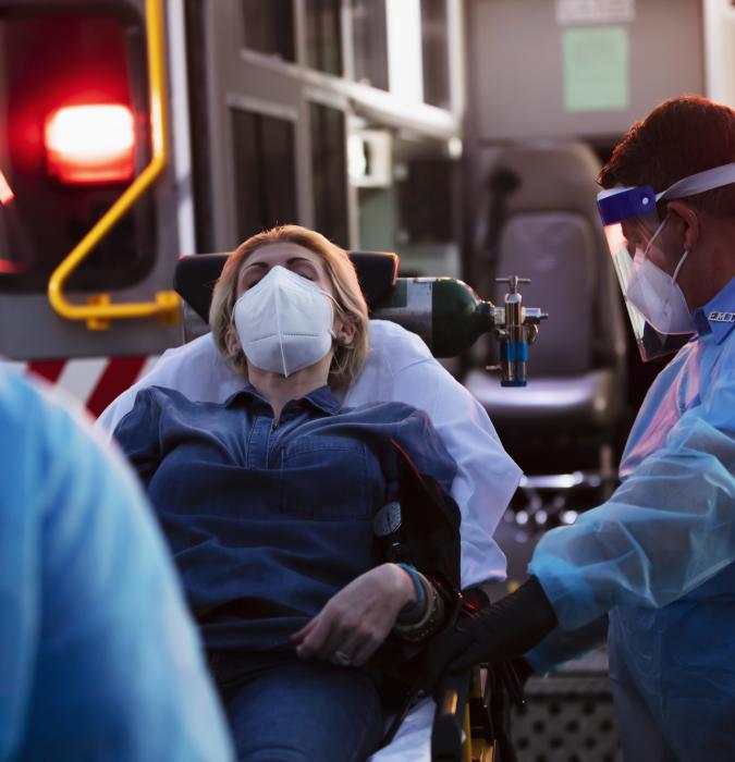 Woman on a stretcher in front of the ER surrounded by trauma Caregivers